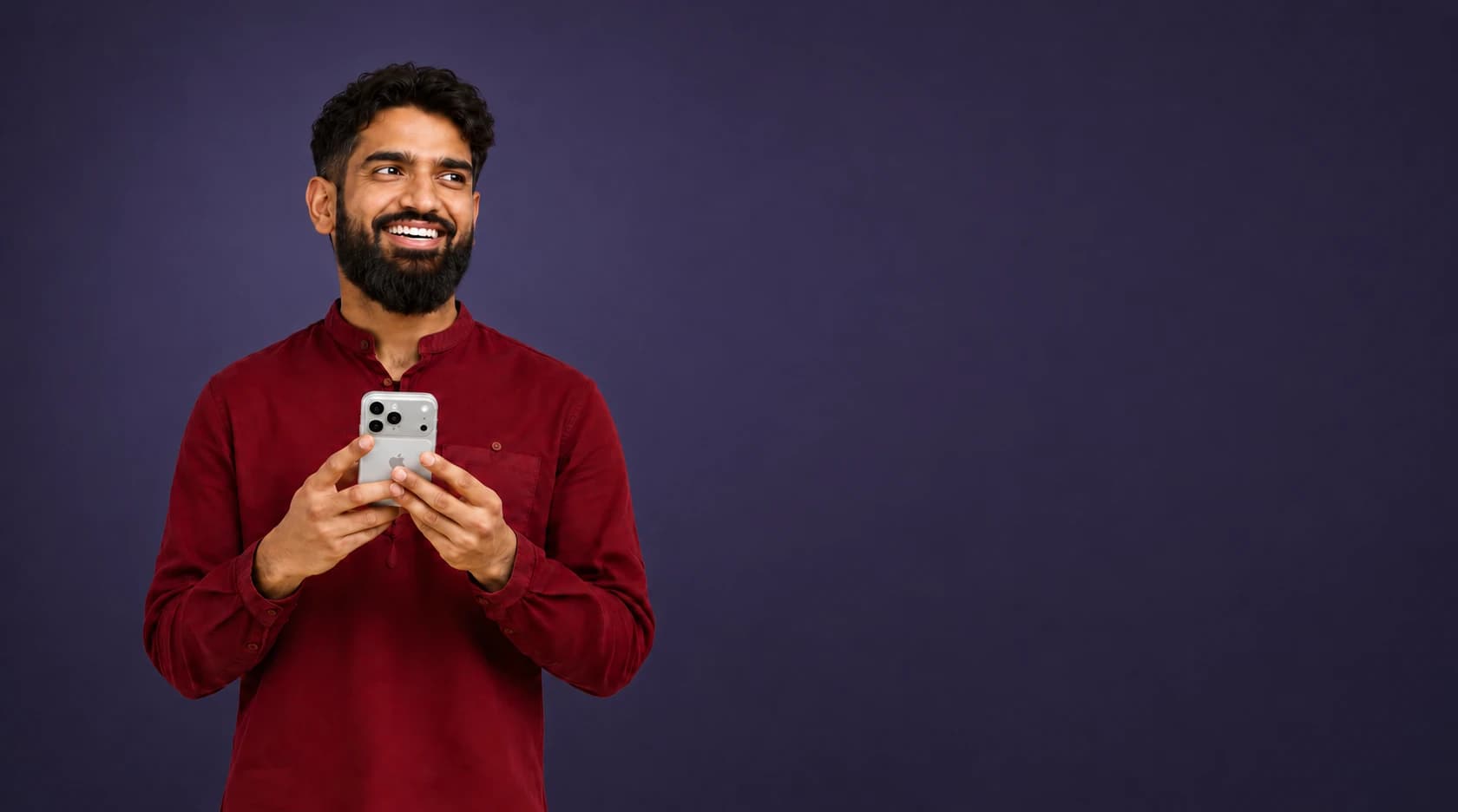 A client holding a phone to book a barber appointment against a dark background