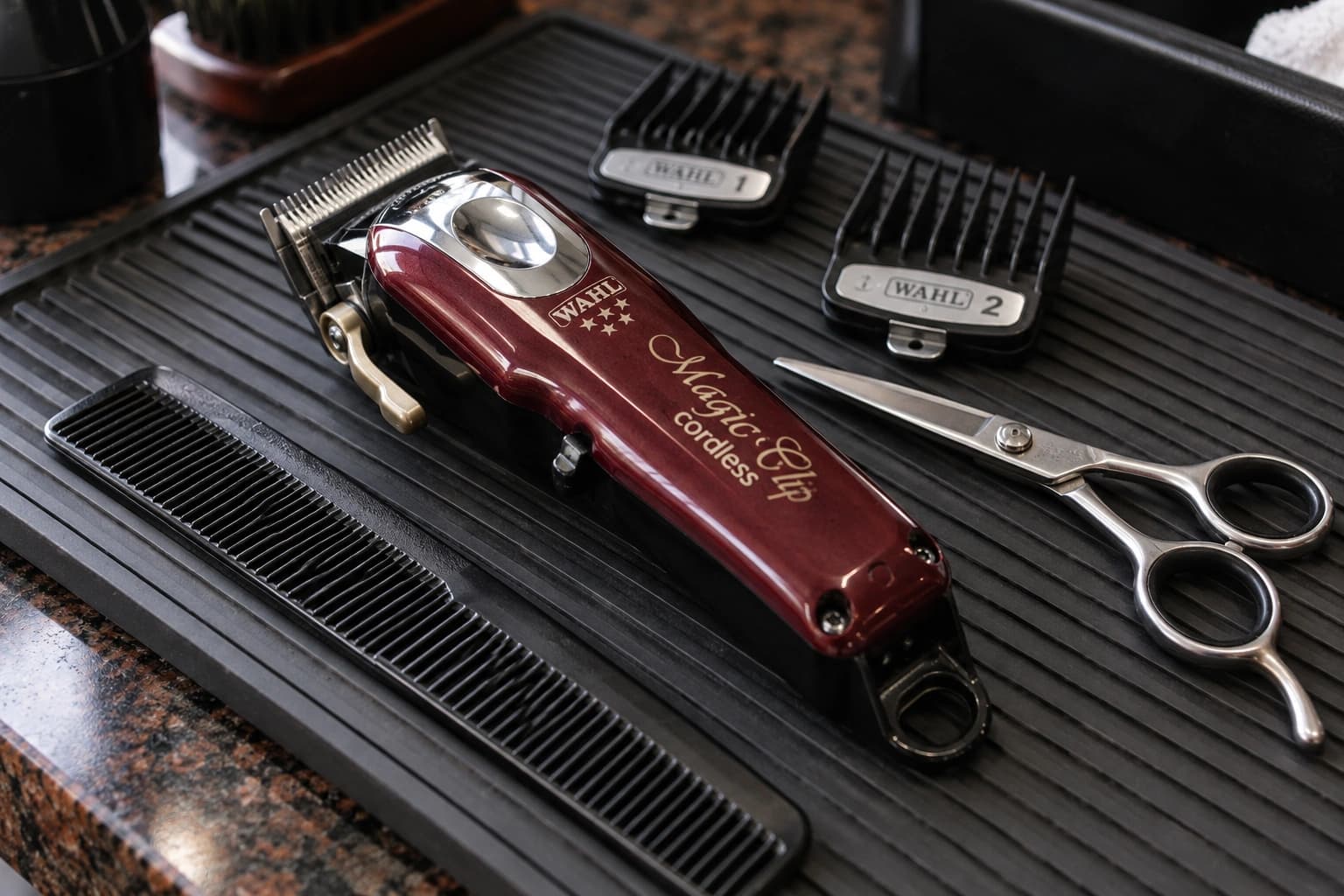 Wahl Magic Clip, guards, scissors and comb on a working barber’s mat