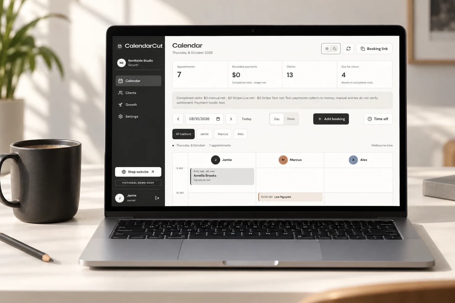 Laptop displaying CalendarCut's sample appointment diary beside a charcoal coffee cup